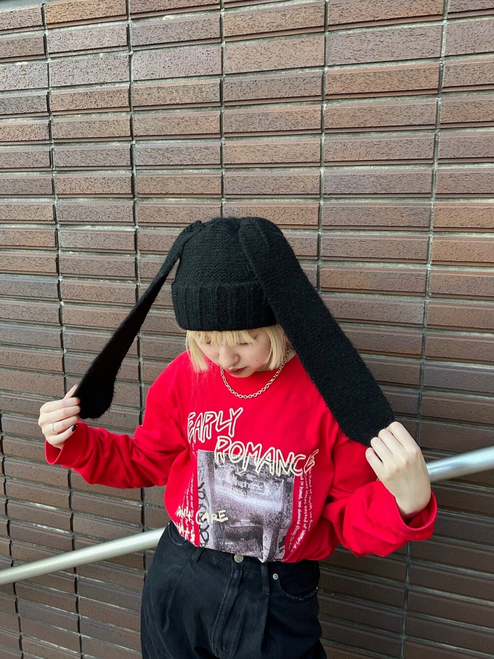 レッド系のTシャツ/カットソー、ブラック系のニットキャップ/ビーニーを着用したレディースの秋コーディネートの3枚目の写真