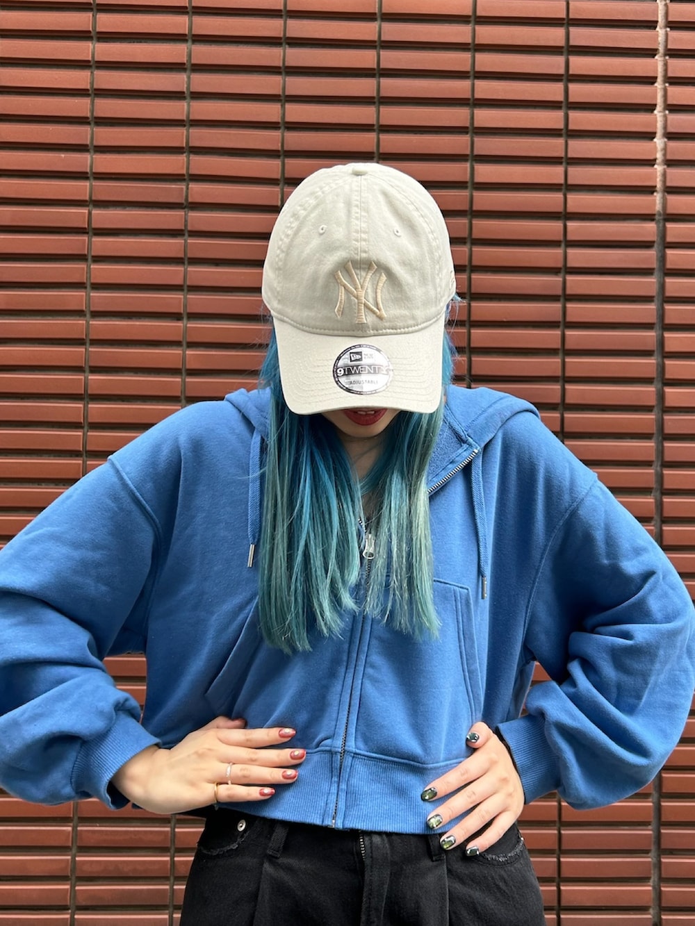 ブラック系のスニーカー、ブラック系のデニムパンツ、ベージュ系のキャップを着用したレディースの春コーディネートの2枚目の写真