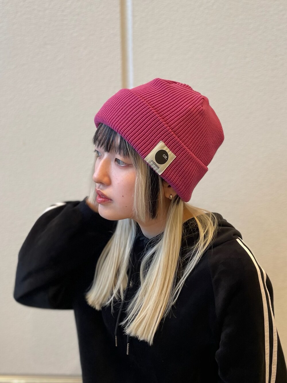 ピンク系のニットキャップ/ビーニーを着用したレディースの春コーディネートの2枚目の写真