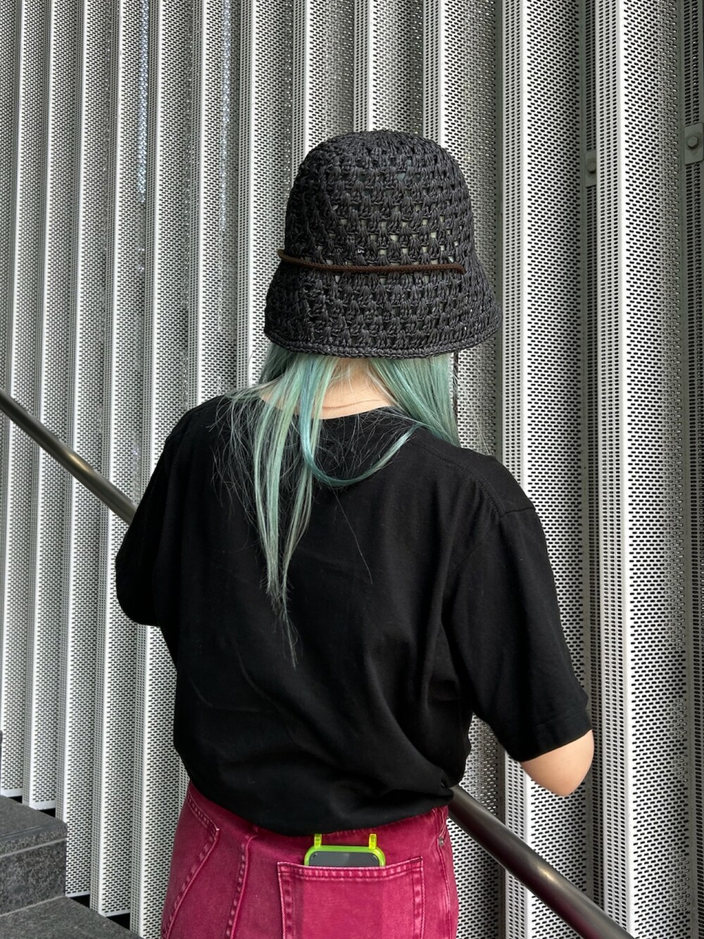 レッド系のデニムパンツ、ブラック系のサンダル、ブラック系のハットを着用したレディースの夏コーディネートの3枚目の写真