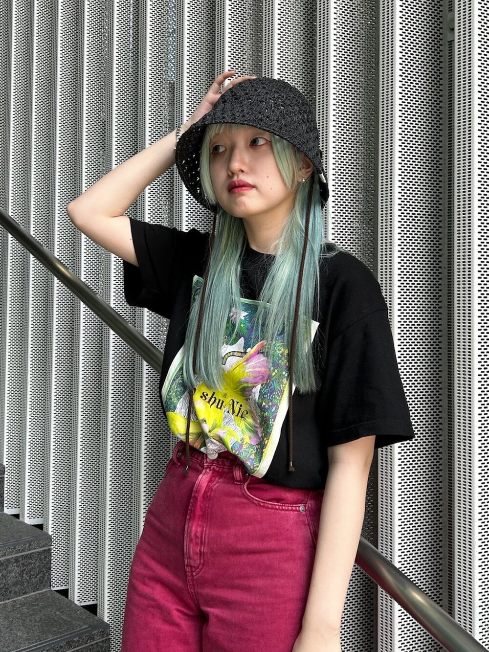 レッド系のデニムパンツ、ブラック系のサンダル、ブラック系のハットを着用したレディースの夏コーディネートの2枚目の写真