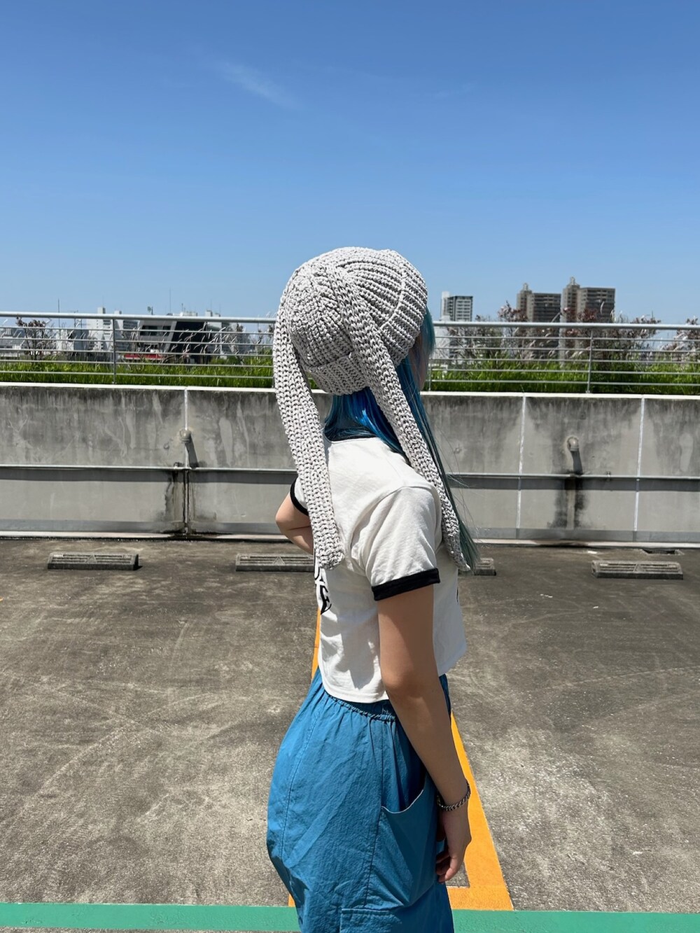 ホワイト系のTシャツ/カットソー、ブルー系のカーゴパンツ、ブラック系のスニーカーを着用したレディースの春コーディネートの4枚目の写真