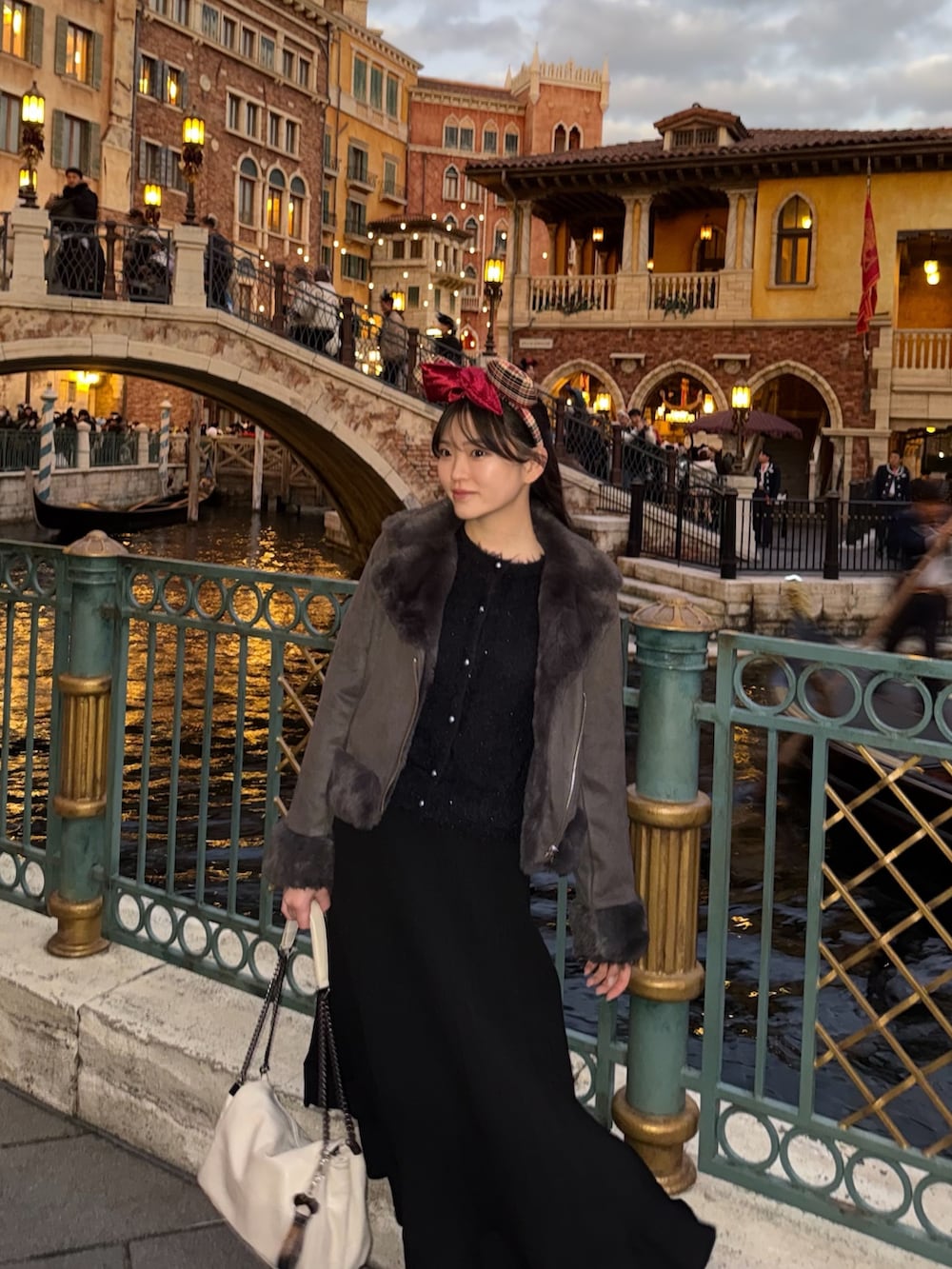 ブラック系のニット/セーター、グレー系のジャケット/アウター、ホワイト系のバッグを着用したレディースの冬コーディネートの2枚目の写真