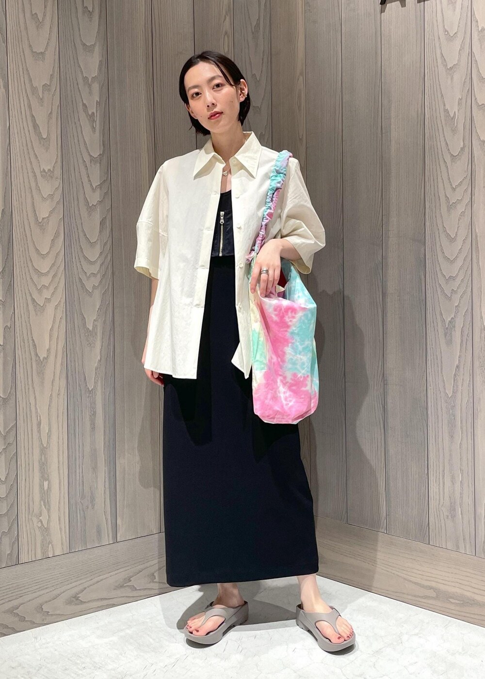 グリーン系のショルダーバッグ、ブラック系のワンピース、ホワイト系のシャツ/ブラウスを着用したレディースの夏コーディネートの2枚目の写真