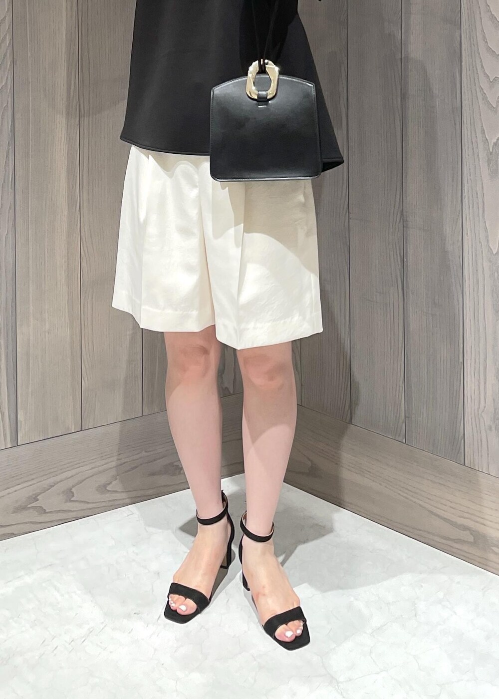 ブラック系のハンドバッグ、ブラック系のサンダル、ホワイト系のその他パンツを着用したレディースの夏コーディネートの4枚目の写真