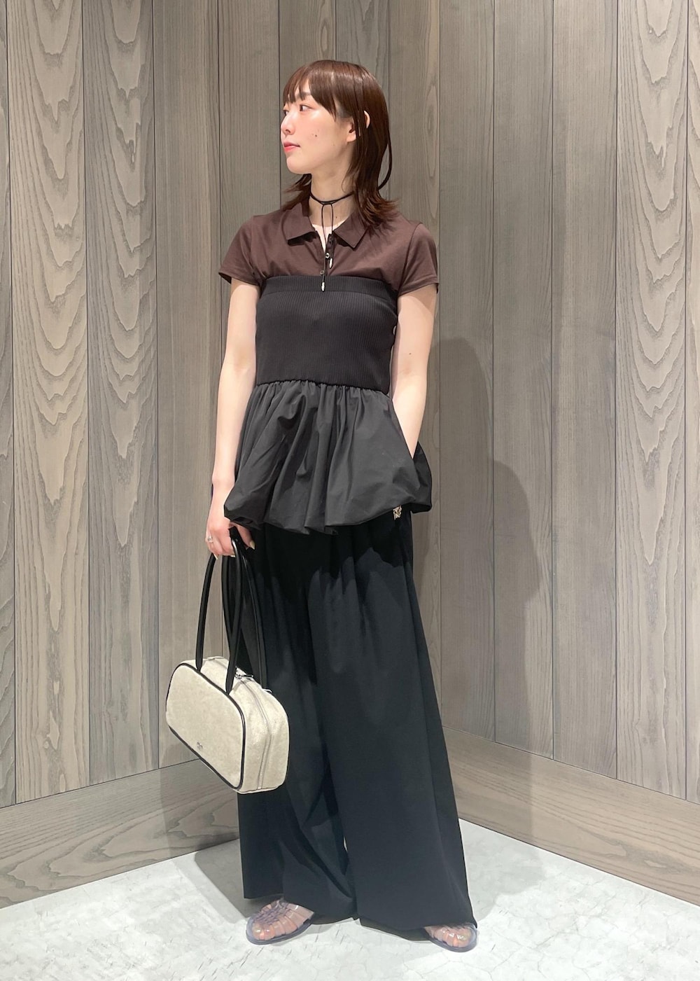 ブラック系のスラックス、ホワイト系のボストンバッグ、ブラック系のTシャツ/カットソーを着用したレディースの春コーディネートの3枚目の写真