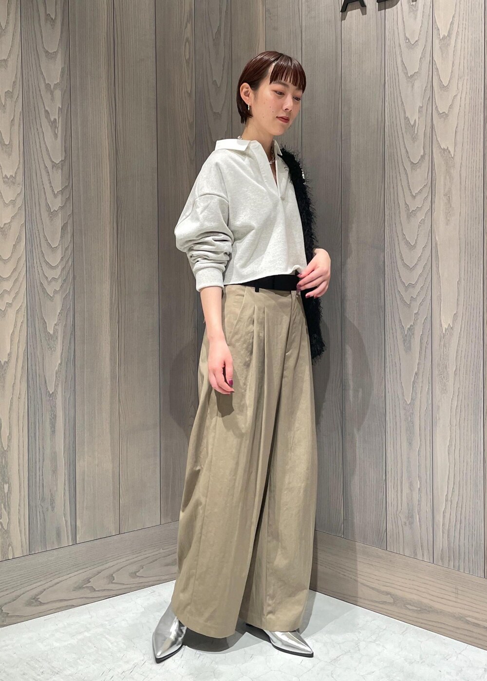 グリーン系のスラックス、ホワイト系のTシャツ/カットソー、シルバー系のブーツを着用したレディースの秋コーディネートの4枚目の写真