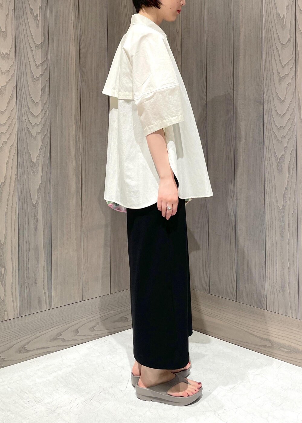 グリーン系のショルダーバッグ、ブラック系のワンピース、ホワイト系のシャツ/ブラウスを着用したレディースの夏コーディネートの5枚目の写真