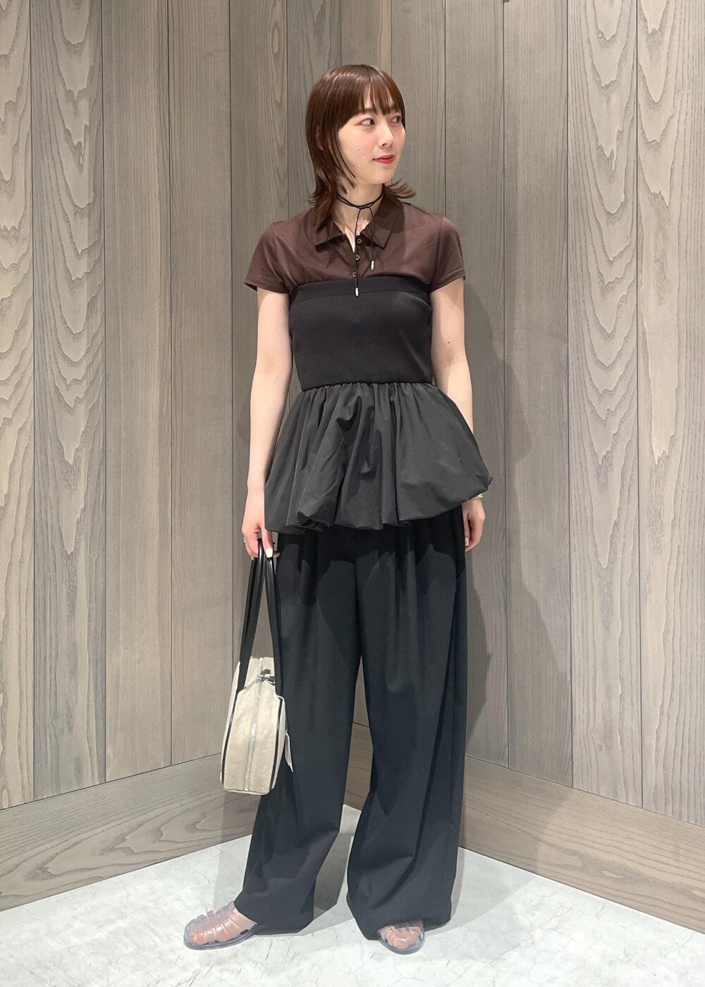 ブラック系のスラックス、ホワイト系のボストンバッグ、ブラック系のTシャツ/カットソーを着用したレディースの春コーディネートの4枚目の写真