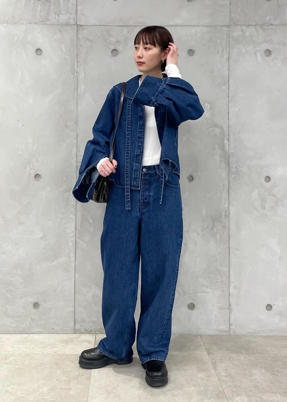 ブラック系のサンダル、ブラウン系のボディバッグ/ウエストポーチ、ホワイト系のTシャツ/カットソーを着用したレディースの秋コーディネートの2枚目の写真