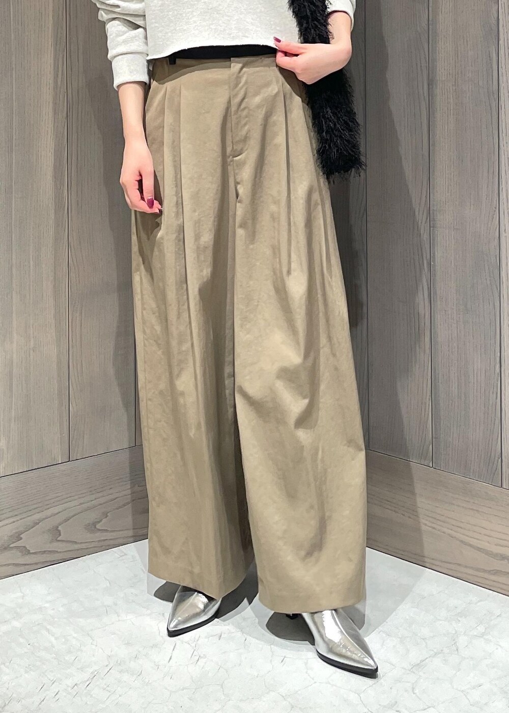 グリーン系のスラックス、ホワイト系のTシャツ/カットソー、シルバー系のブーツを着用したレディースの秋コーディネートの7枚目の写真