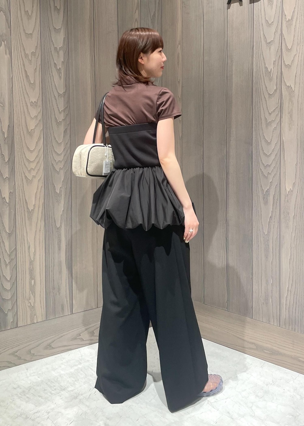 ブラック系のスラックス、ホワイト系のボストンバッグ、ブラック系のTシャツ/カットソーを着用したレディースの春コーディネートの7枚目の写真