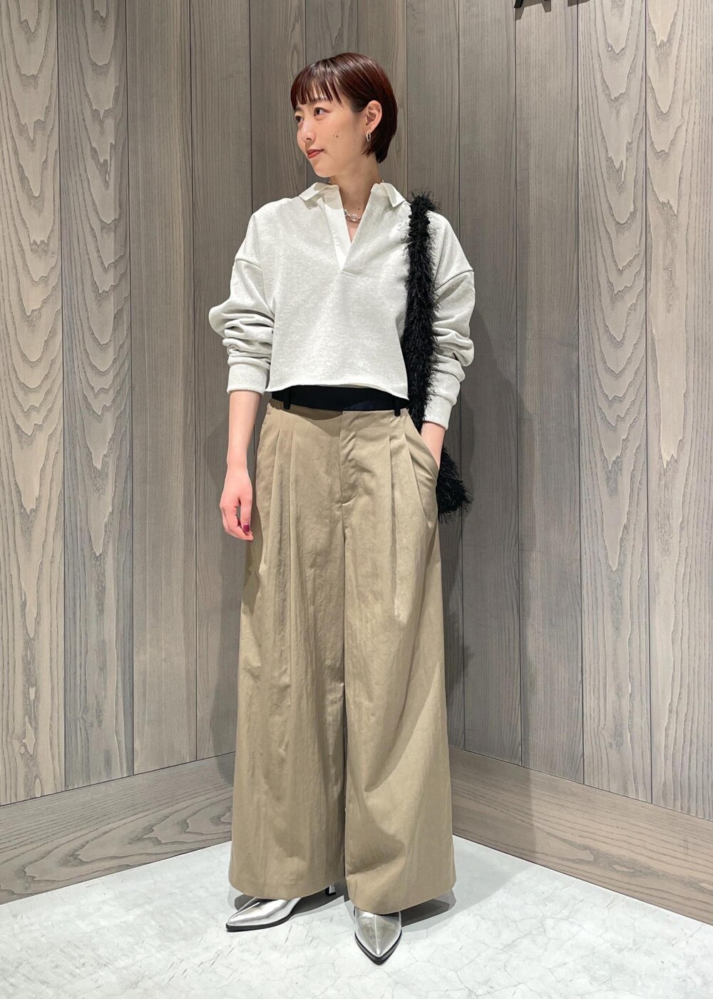 グリーン系のスラックス、ホワイト系のTシャツ/カットソー、シルバー系のブーツを着用したレディースの秋コーディネートの2枚目の写真