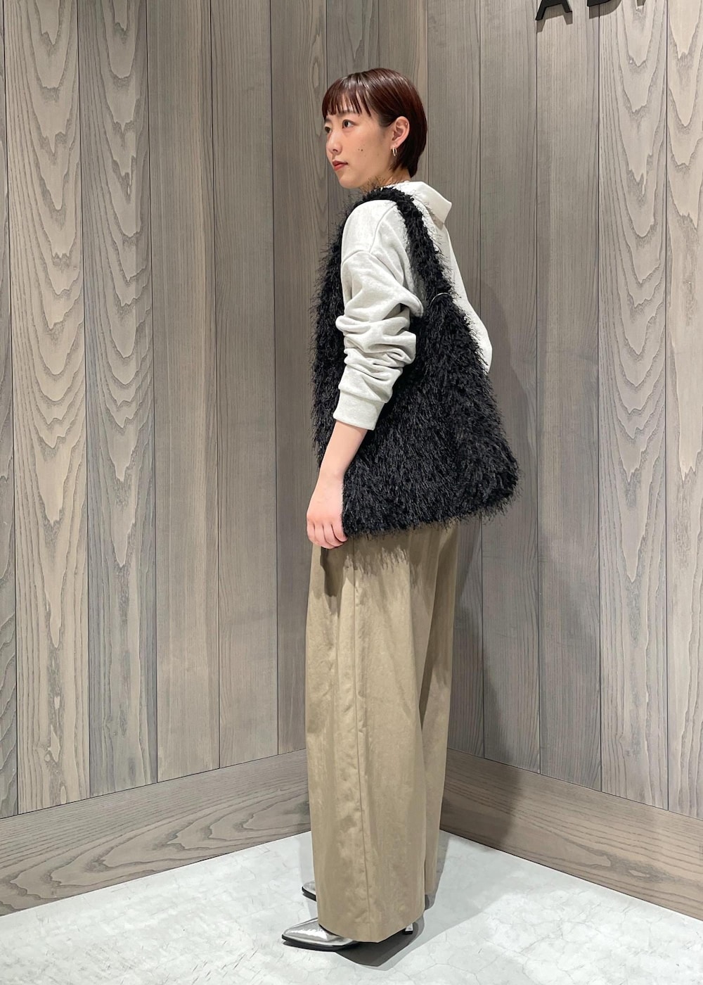 グリーン系のスラックス、ホワイト系のTシャツ/カットソー、シルバー系のブーツを着用したレディースの秋コーディネートの5枚目の写真