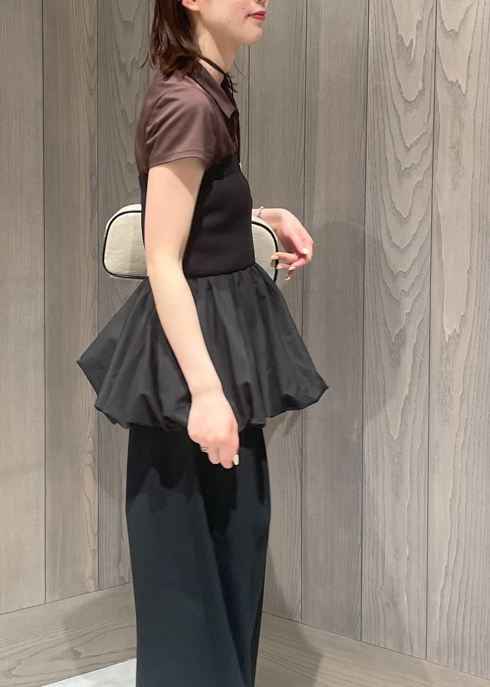 ブラック系のスラックス、ホワイト系のボストンバッグ、ブラック系のTシャツ/カットソーを着用したレディースの春コーディネートの5枚目の写真