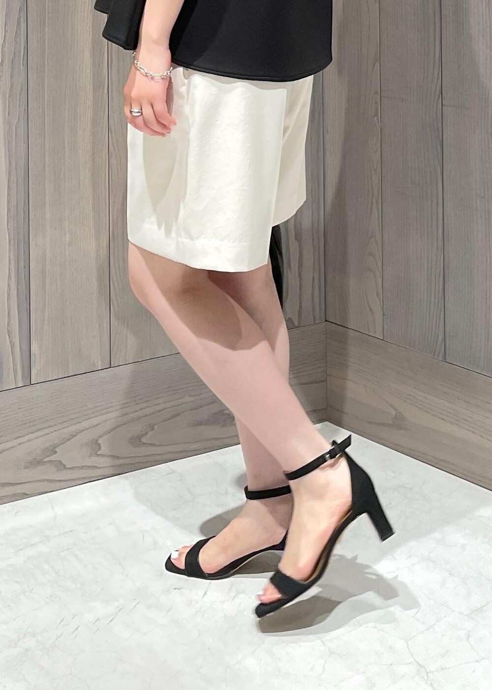 ブラック系のハンドバッグ、ブラック系のサンダル、ホワイト系のその他パンツを着用したレディースの夏コーディネートの5枚目の写真