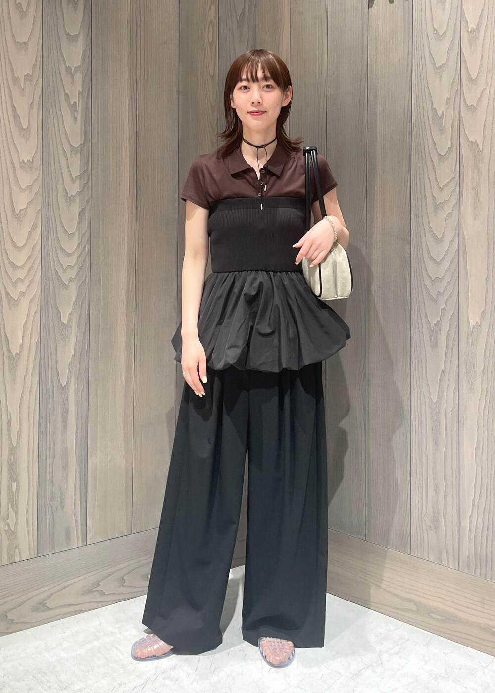 ブラック系のスラックス、ホワイト系のボストンバッグ、ブラック系のTシャツ/カットソーを着用したレディースの春コーディネートの2枚目の写真