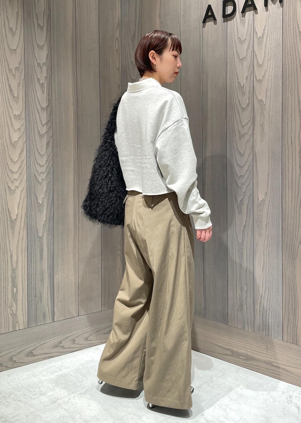 グリーン系のスラックス、ホワイト系のTシャツ/カットソー、シルバー系のブーツを着用したレディースの秋コーディネートの9枚目の写真