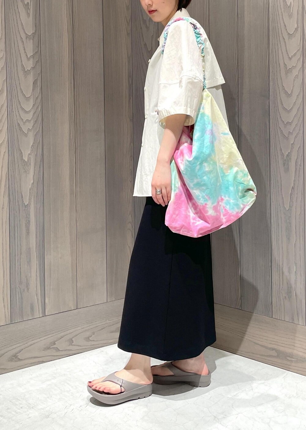 グリーン系のショルダーバッグ、ブラック系のワンピース、ホワイト系のシャツ/ブラウスを着用したレディースの夏コーディネートの3枚目の写真