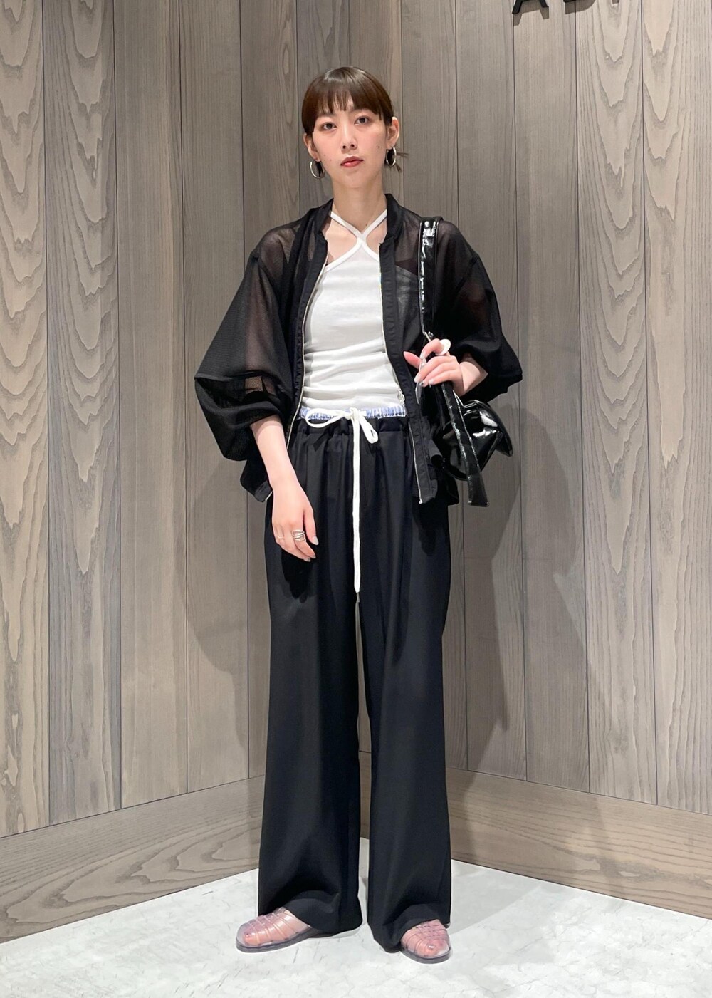 ホワイト系のキャミソール、ブラック系のショルダーバッグ、ブラック系のカーディガン/ボレロを着用したレディースの夏コーディネートの3枚目の写真