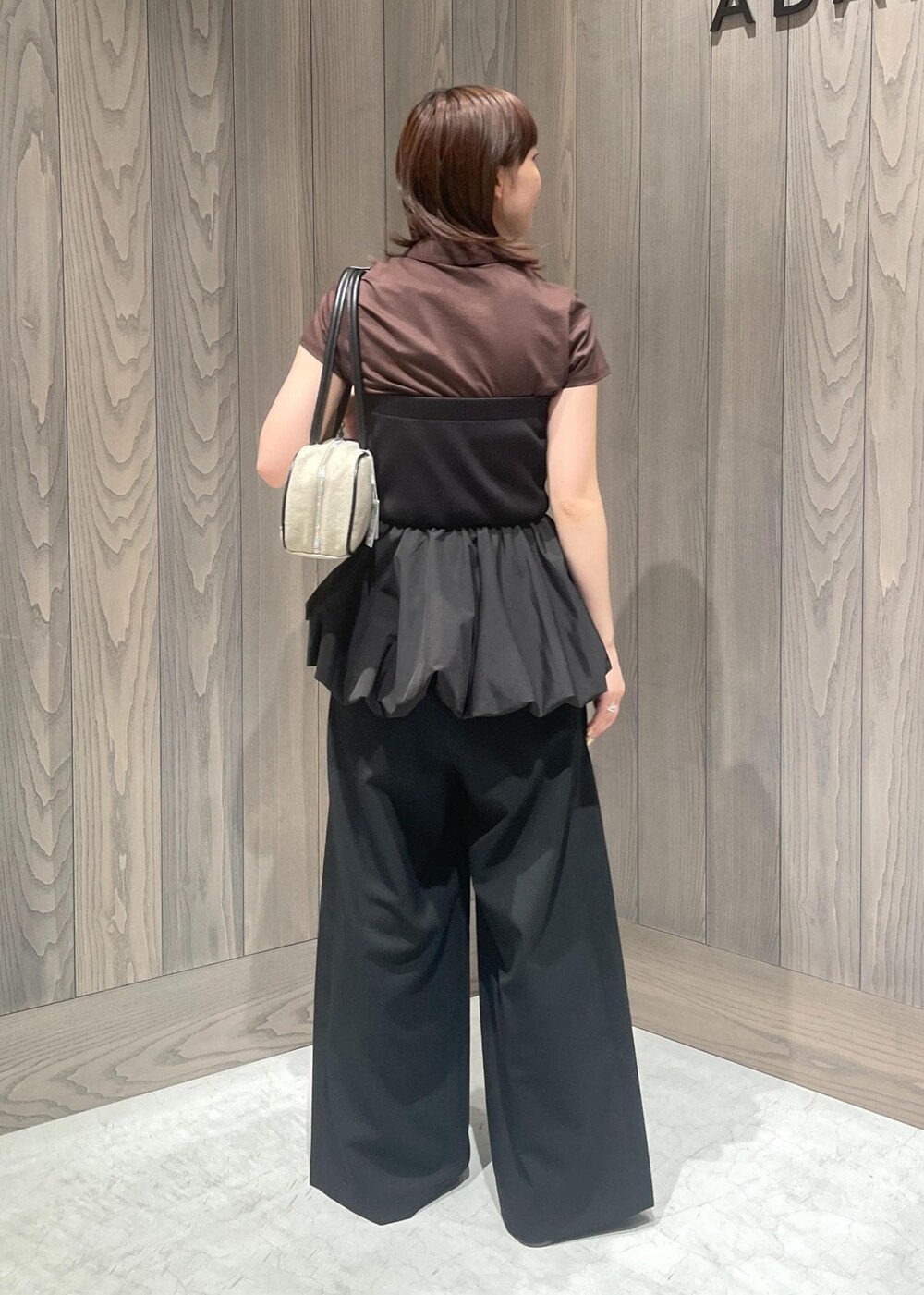 ブラック系のスラックス、ホワイト系のボストンバッグ、ブラック系のTシャツ/カットソーを着用したレディースの春コーディネートの6枚目の写真