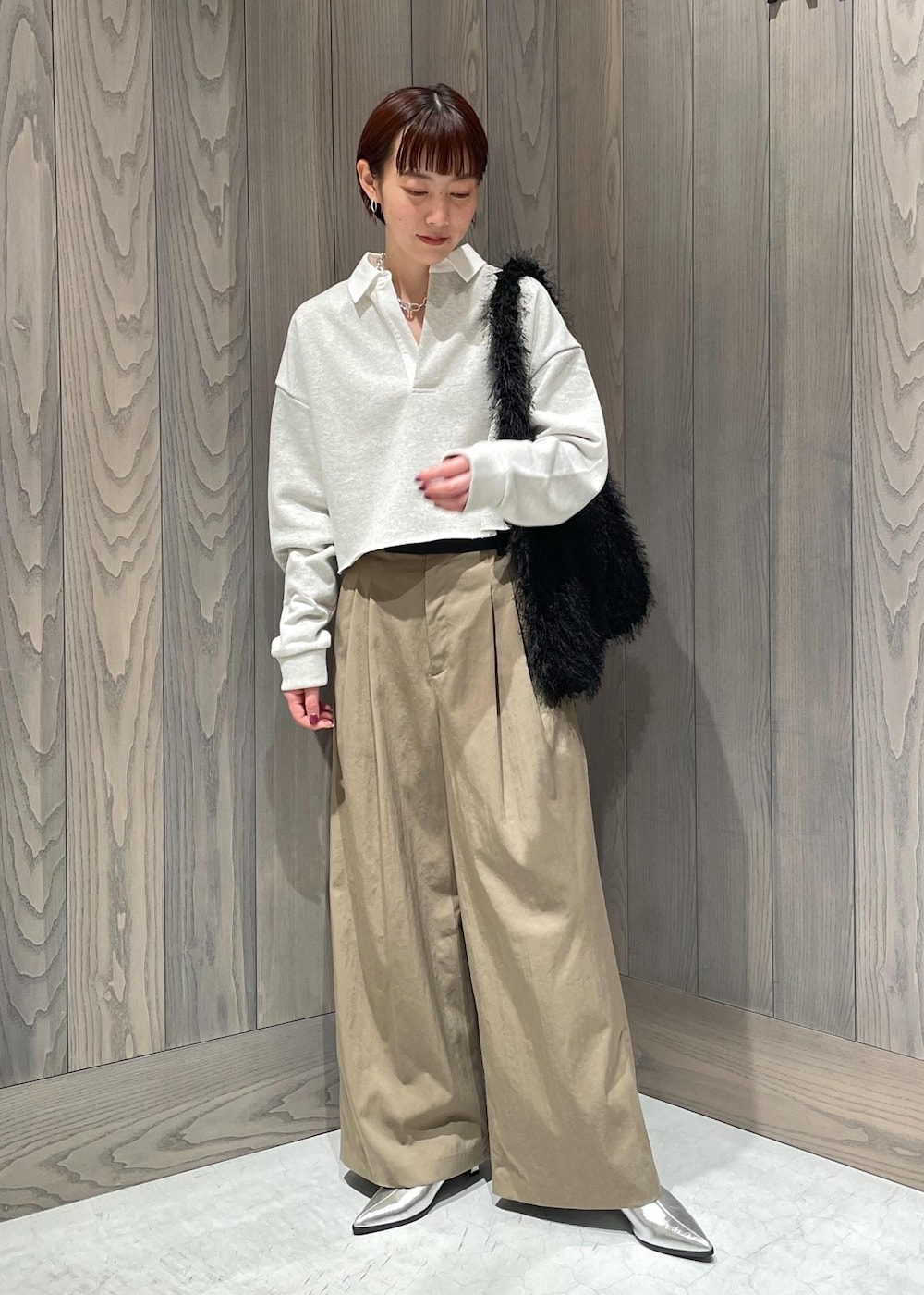 グリーン系のスラックス、ホワイト系のTシャツ/カットソー、シルバー系のブーツを着用したレディースの秋コーディネートの3枚目の写真