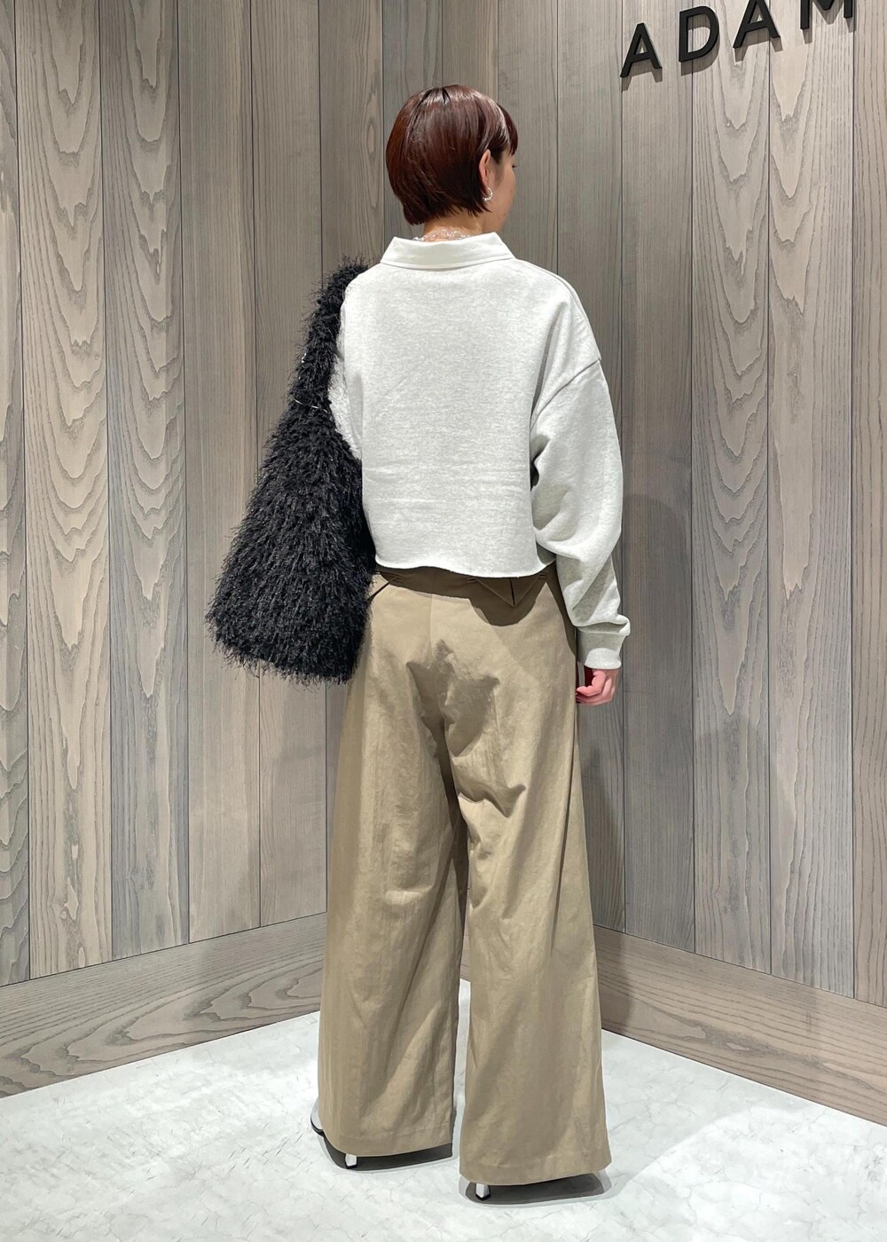 グリーン系のスラックス、ホワイト系のTシャツ/カットソー、シルバー系のブーツを着用したレディースの秋コーディネートの6枚目の写真