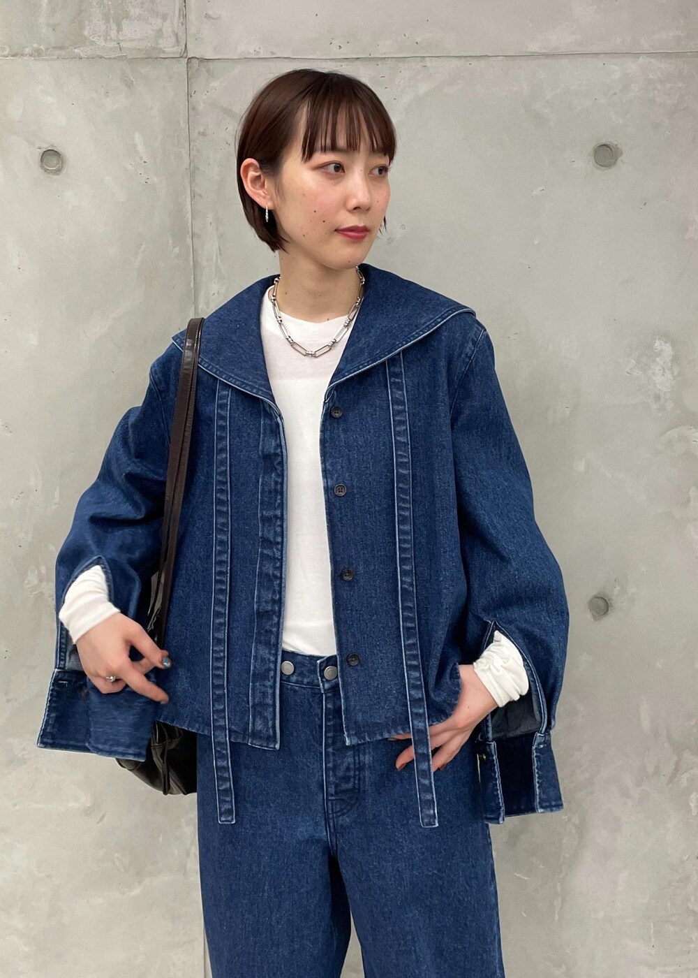 ブラック系のサンダル、ブラウン系のボディバッグ/ウエストポーチ、ホワイト系のTシャツ/カットソーを着用したレディースの秋コーディネートの6枚目の写真