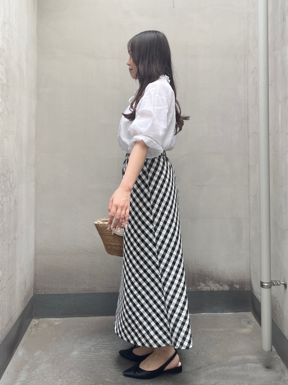 ブラック系のスカート、ホワイト系のシャツ/ブラウスを着用したレディースの夏コーディネートの4枚目の写真