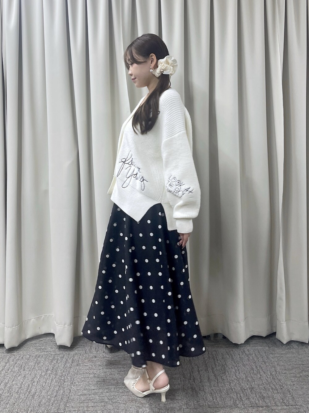 ブルー系のスカート、ホワイト系のカーディガン/ボレロを着用したレディースの秋コーディネートの3枚目の写真