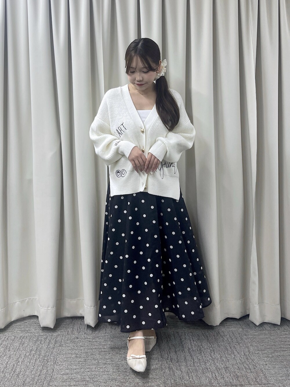 ブルー系のスカート、ホワイト系のカーディガン/ボレロを着用したレディースの秋コーディネートの6枚目の写真