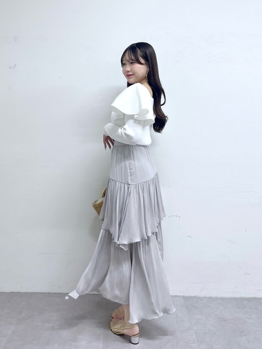 ホワイト系のニット/セーター、グレー系のスカートを着用したレディースの冬コーディネートの2枚目の写真