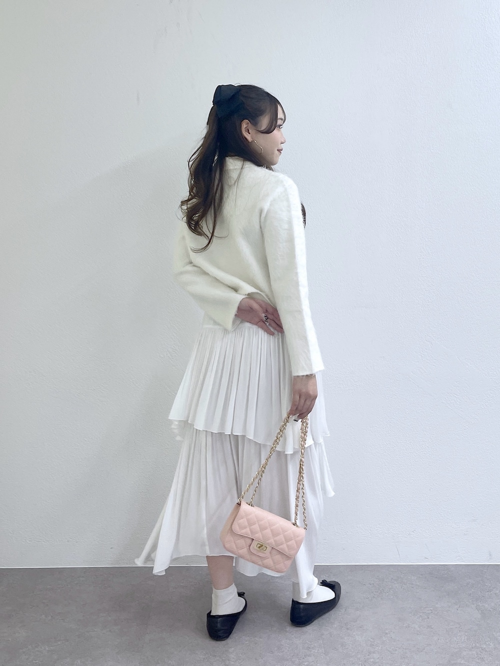 ホワイト系のその他アウター、ホワイト系のスカート、ピンク系のハンドバッグを着用したレディースの秋コーディネートの3枚目の写真