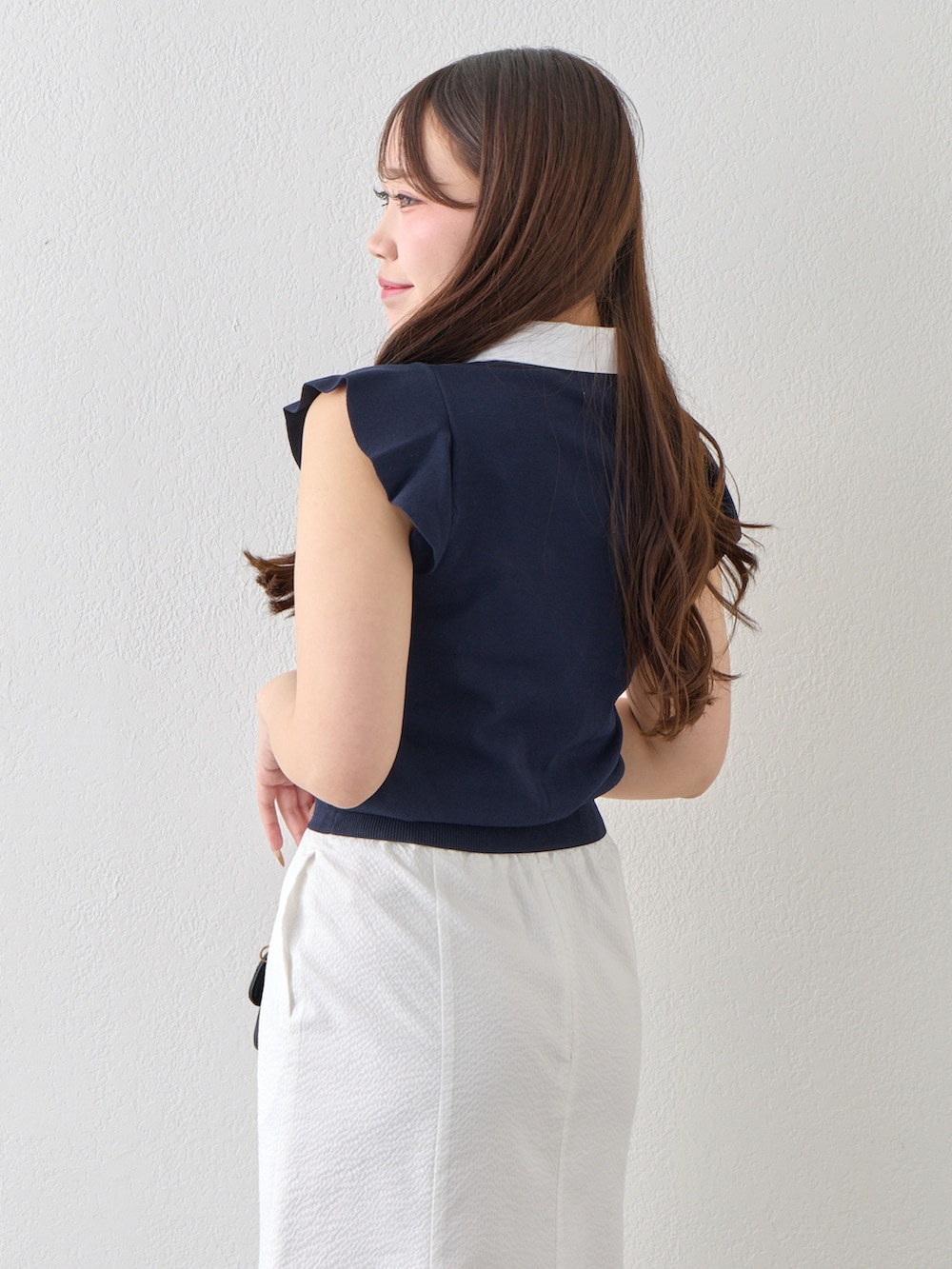 ブルー系のニット/セーター、ホワイト系のスカートを着用したレディースの春コーディネートの7枚目の写真