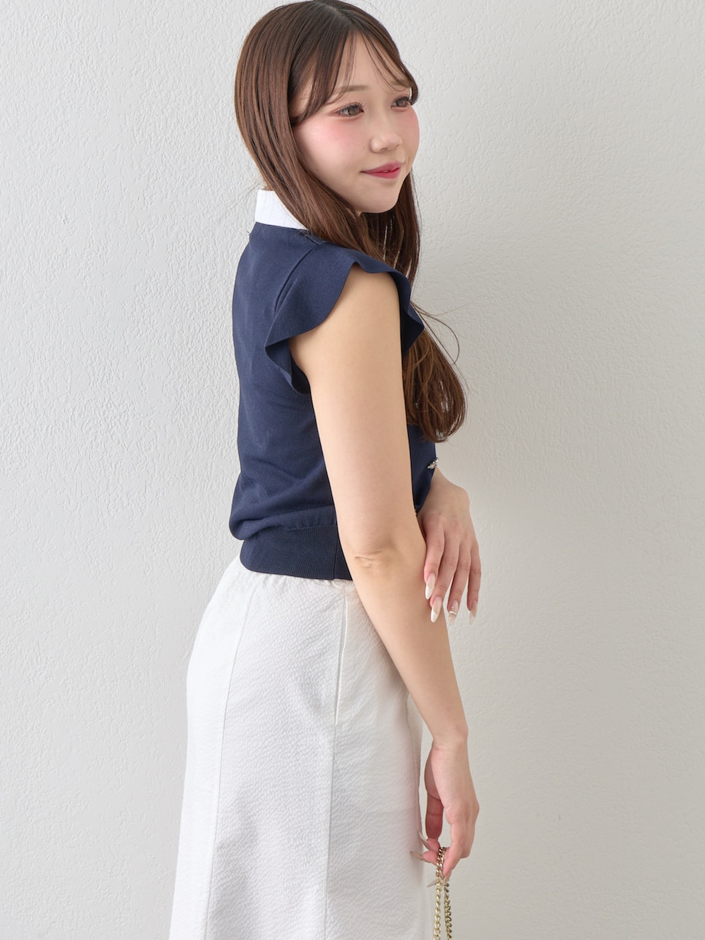 ブルー系のニット/セーター、ホワイト系のスカートを着用したレディースの春コーディネートの9枚目の写真