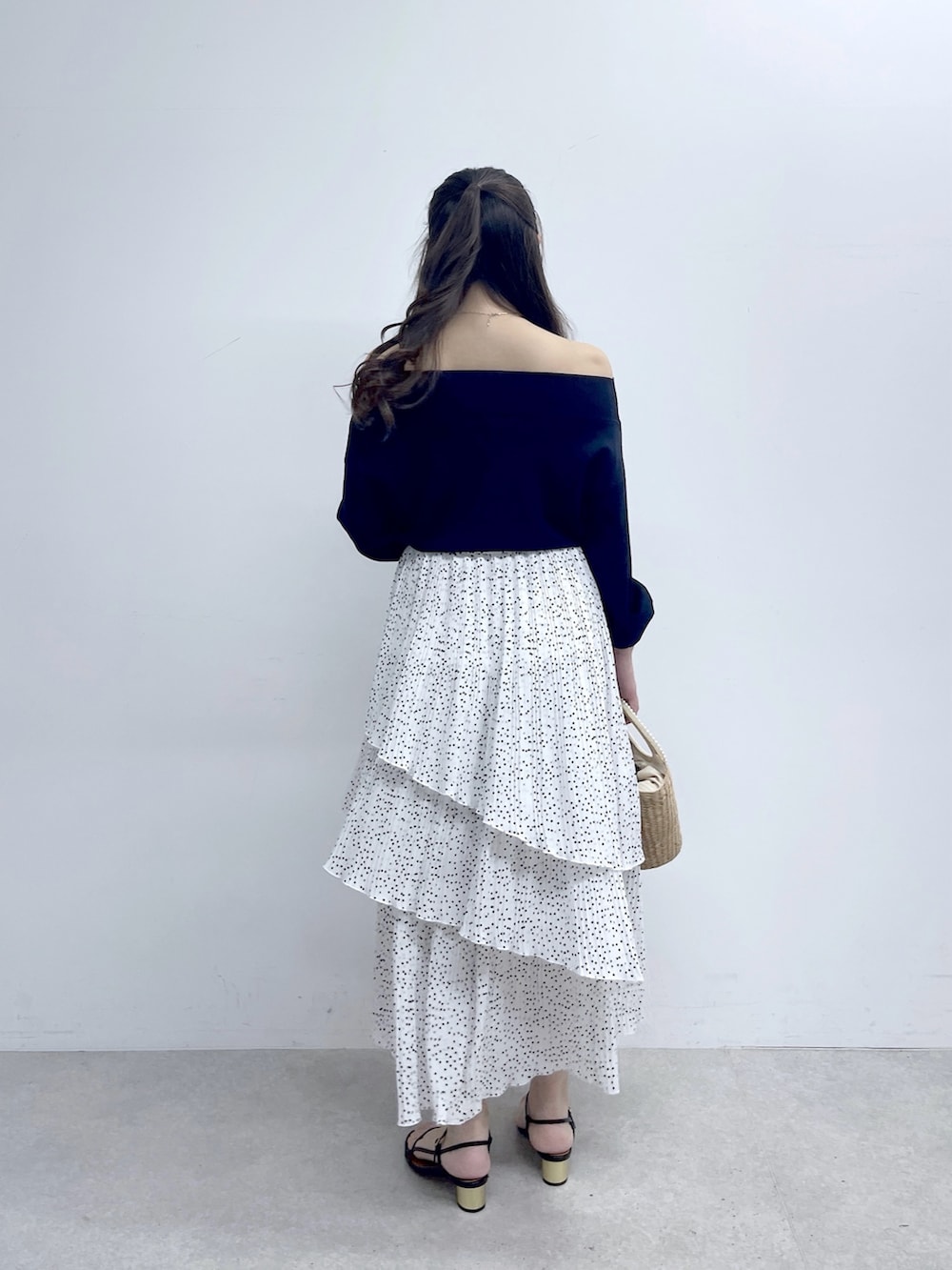 ブルー系のニット/セーター、ホワイト系のスカートを着用したレディースの春コーディネートの4枚目の写真