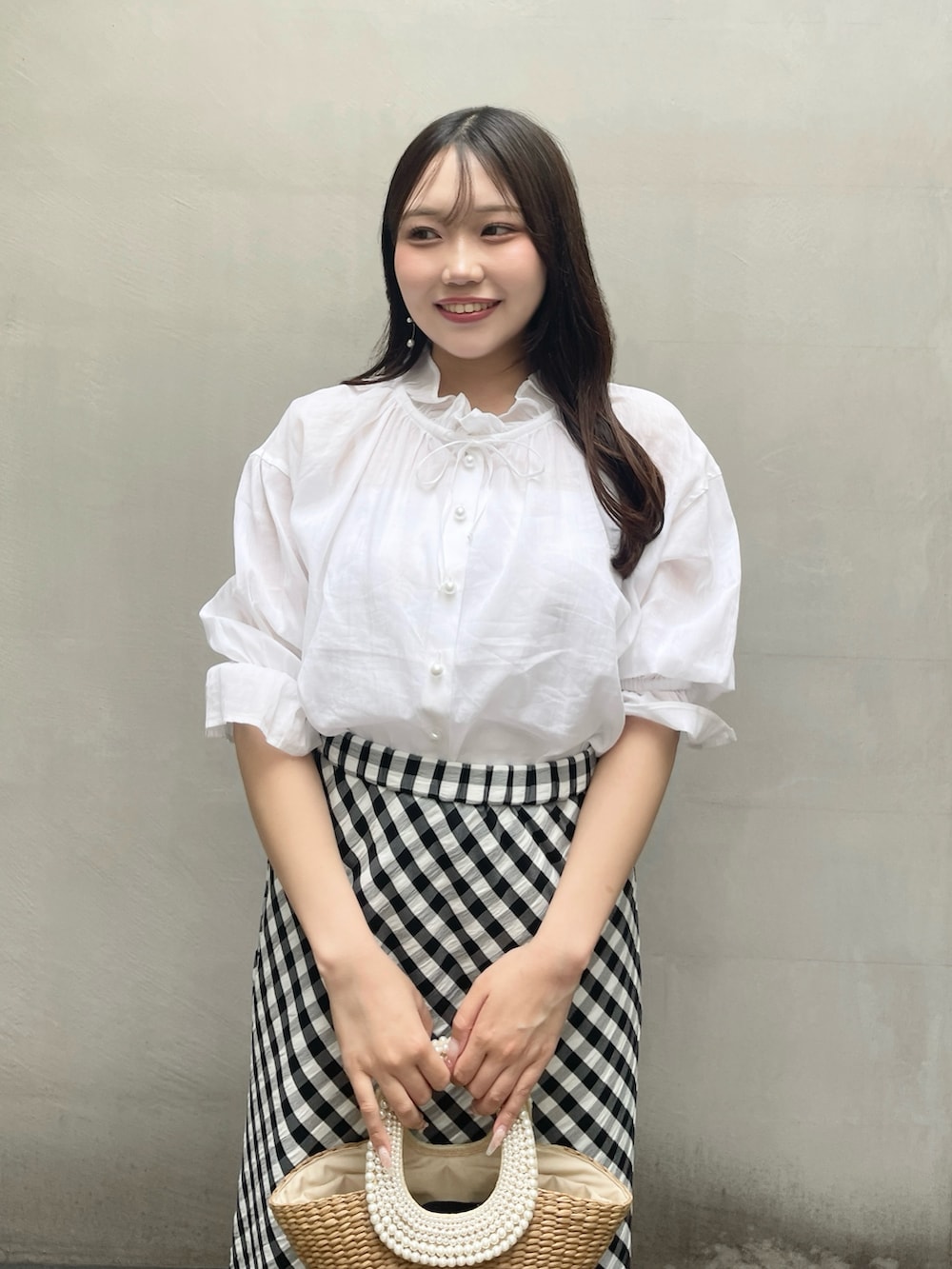 ブラック系のスカート、ホワイト系のシャツ/ブラウスを着用したレディースの夏コーディネートの3枚目の写真