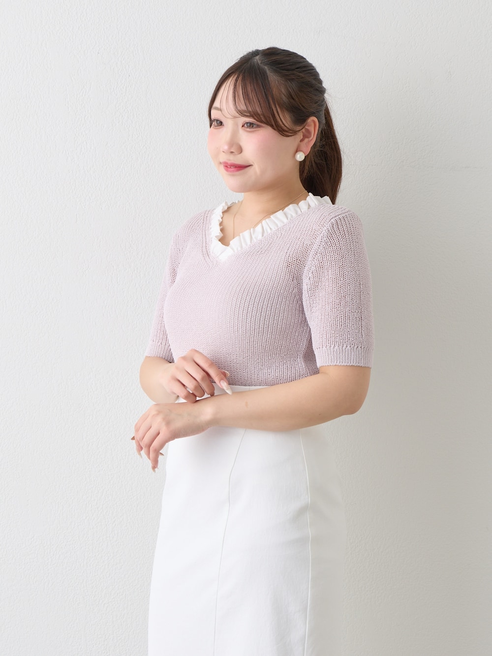 パープル系のニット/セーター、ホワイト系のスカートを着用したレディースの春コーディネートの5枚目の写真