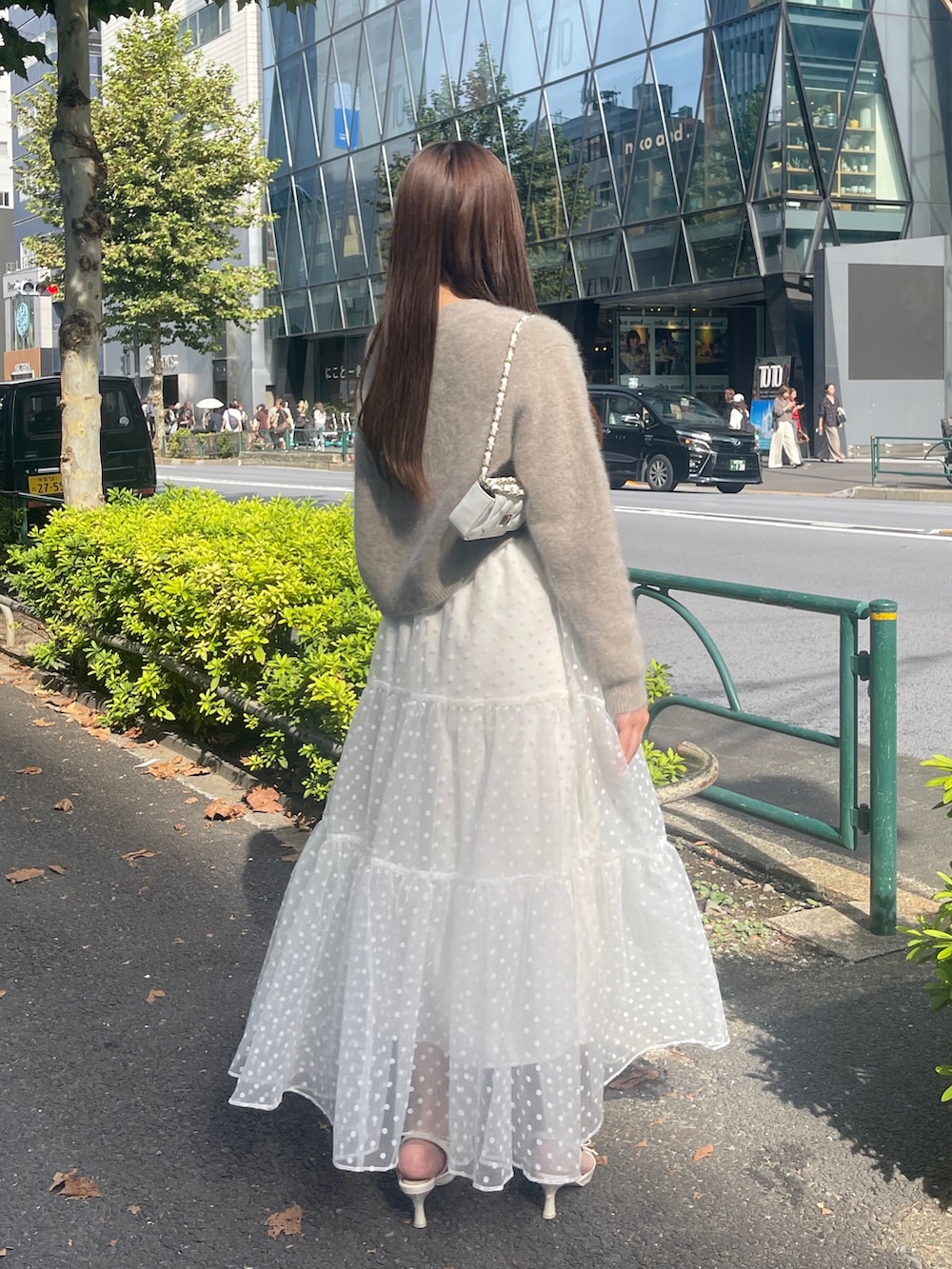 ブラウン系のカーディガン/ボレロ、ホワイト系のスカートを着用したレディースの秋コーディネートの6枚目の写真