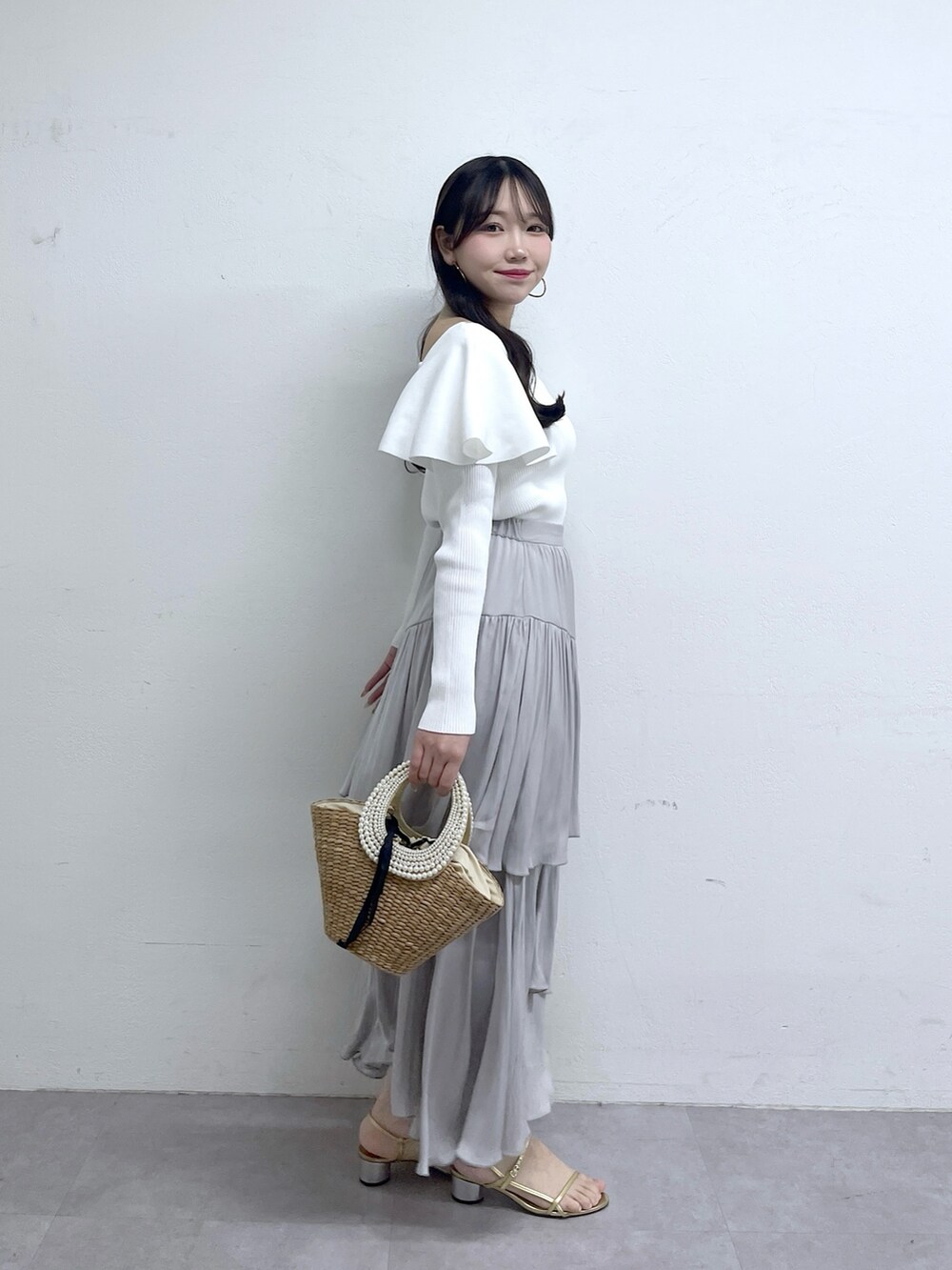 ホワイト系のニット/セーター、グレー系のスカートを着用したレディースの冬コーディネートの3枚目の写真