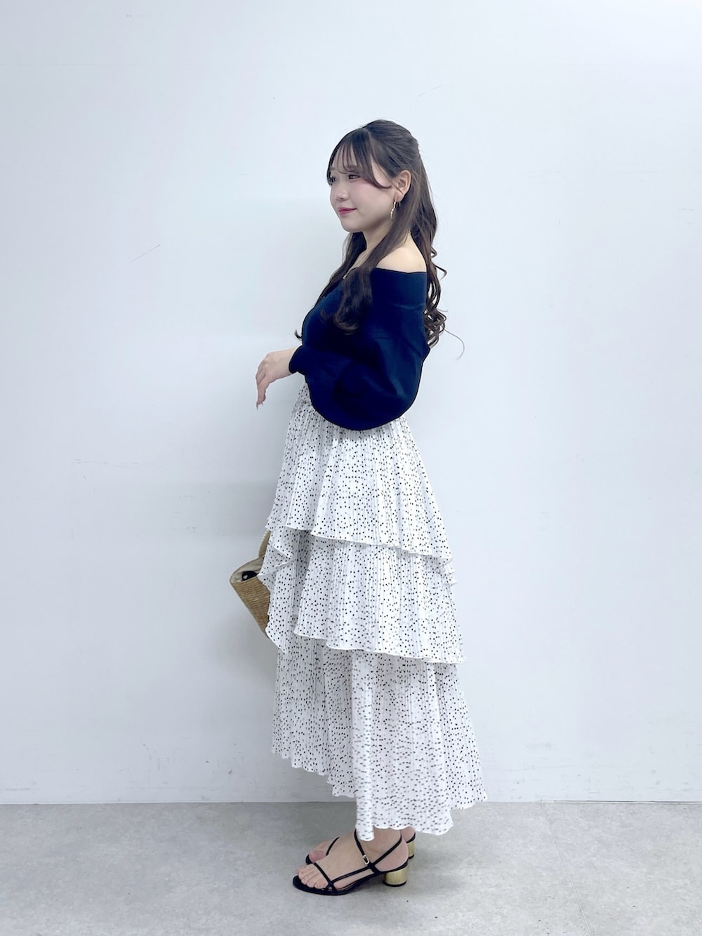 ブルー系のニット/セーター、ホワイト系のスカートを着用したレディースの春コーディネートの3枚目の写真