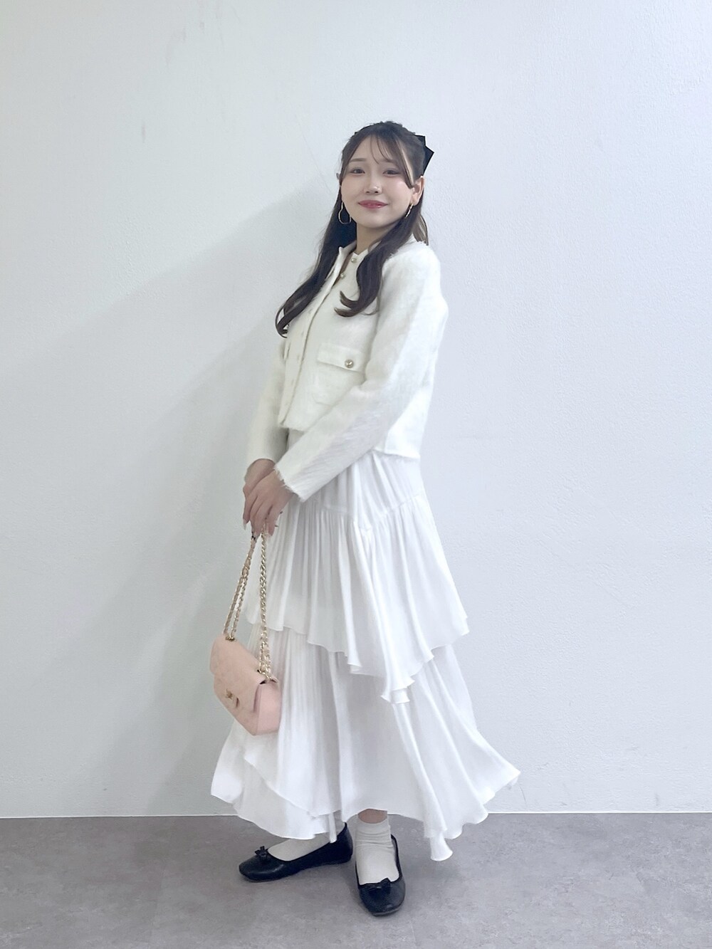 ホワイト系のその他アウター、ホワイト系のスカート、ピンク系のハンドバッグを着用したレディースの秋コーディネートの4枚目の写真