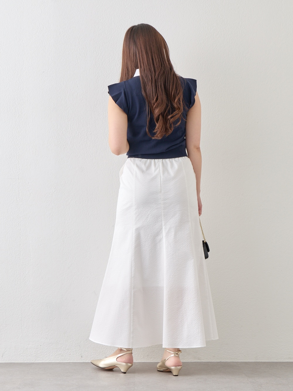 ブルー系のニット/セーター、ホワイト系のスカートを着用したレディースの春コーディネートの4枚目の写真