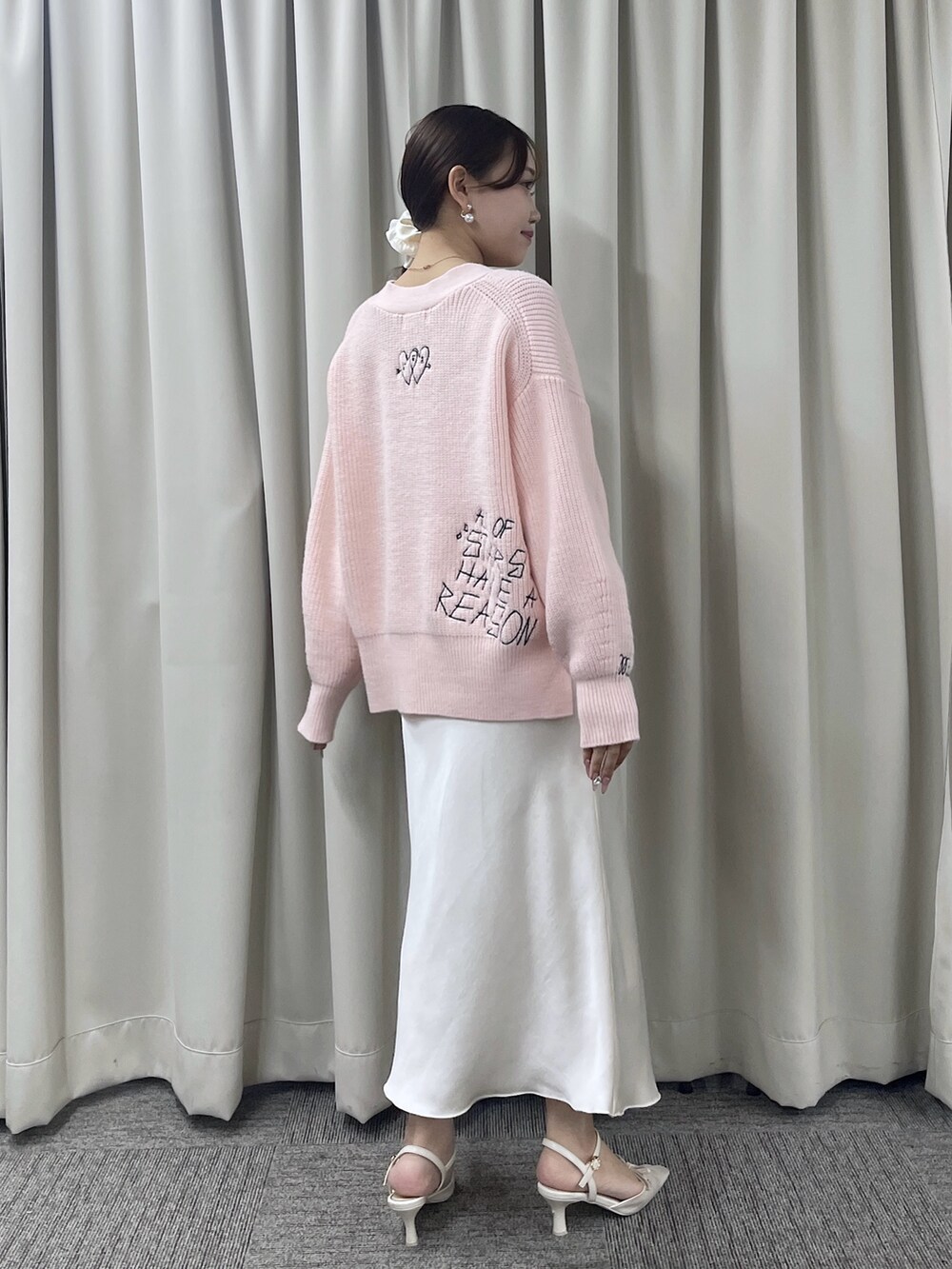 ピンク系のカーディガン/ボレロ、ホワイト系のスカートを着用したレディースの秋コーディネートの4枚目の写真