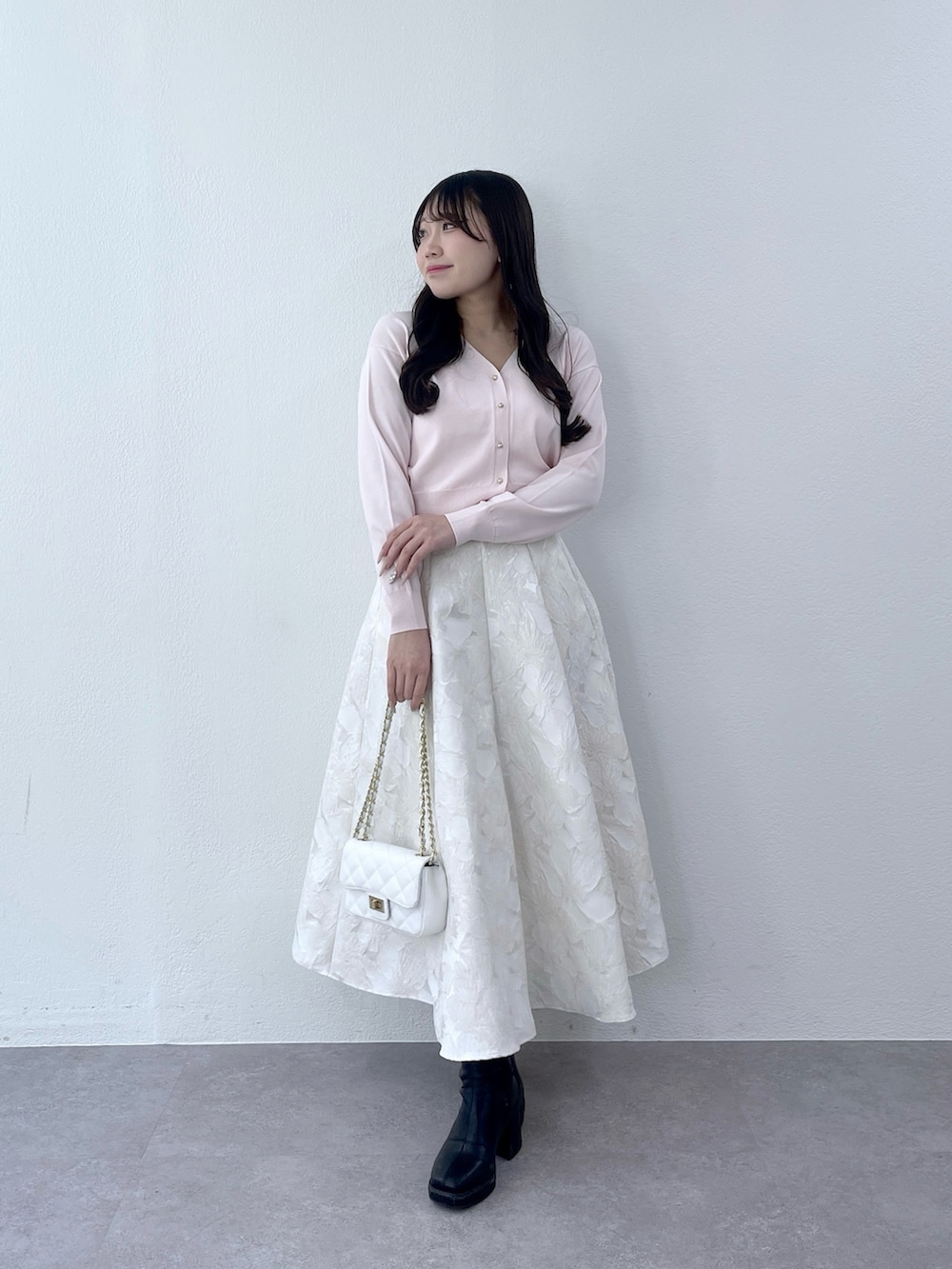 ピンク系のカーディガン/ボレロ、ホワイト系のスカートを着用したレディースの冬コーディネートの2枚目の写真