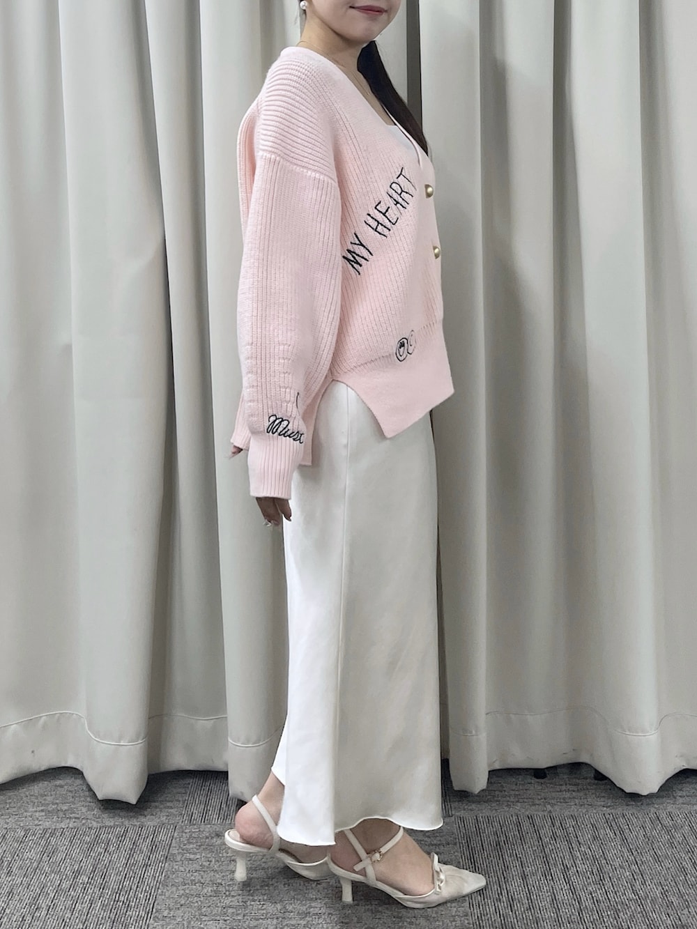 ピンク系のカーディガン/ボレロ、ホワイト系のスカートを着用したレディースの秋コーディネートの3枚目の写真