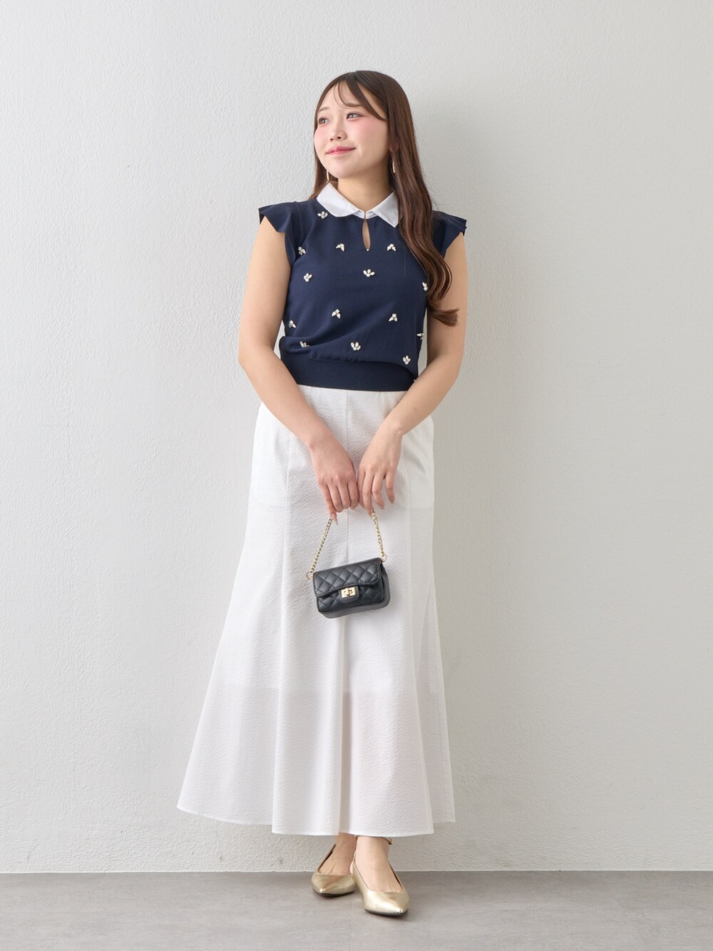 ブルー系のニット/セーター、ホワイト系のスカートを着用したレディースの春コーディネートの10枚目の写真