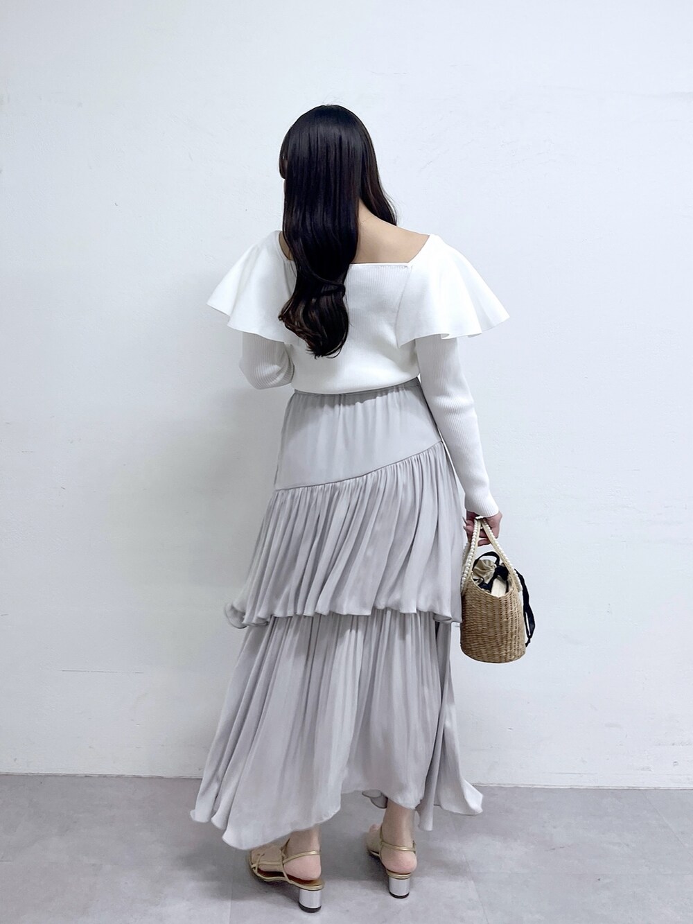 ホワイト系のニット/セーター、グレー系のスカートを着用したレディースの冬コーディネートの4枚目の写真