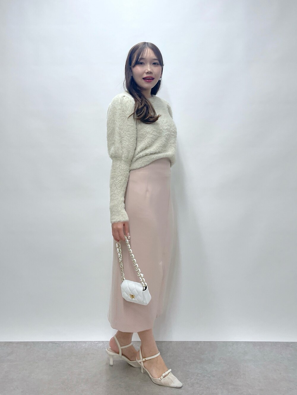 ベージュ系のニット/セーター、ピンク系のスカートを着用したレディースの秋コーディネートの3枚目の写真