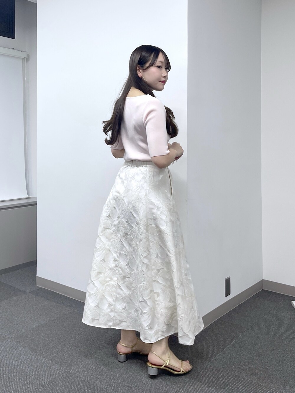 ピンク系のニット/セーター、ホワイト系のスカートを着用したレディースの春コーディネートの3枚目の写真